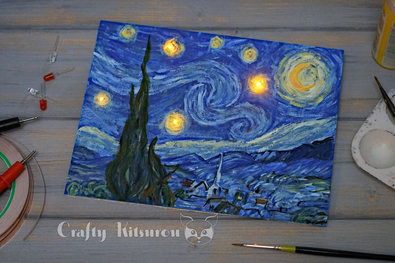 Painting of Van Gogh's Starry Night with yellow LEDs in 4 of the stars surrounded by painting supplies, LEDs, and conductive tape.